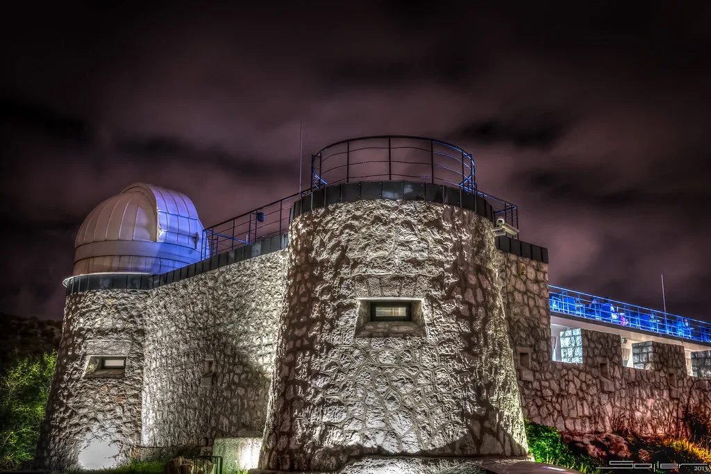 The illuminated observatory dome and stone tower of the Astronomical Centre Rijeka