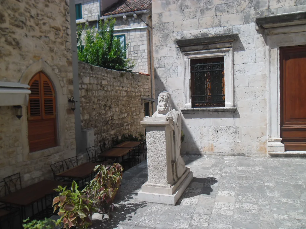 A small courtyard with a stone bust beside the Benedictine nunnery in Hvar Town