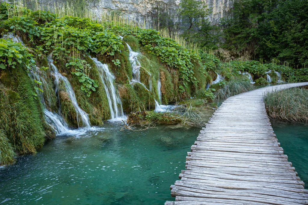 Cascades and a wooden boardwalk between the lakes in Plitvice Lakes National Park.