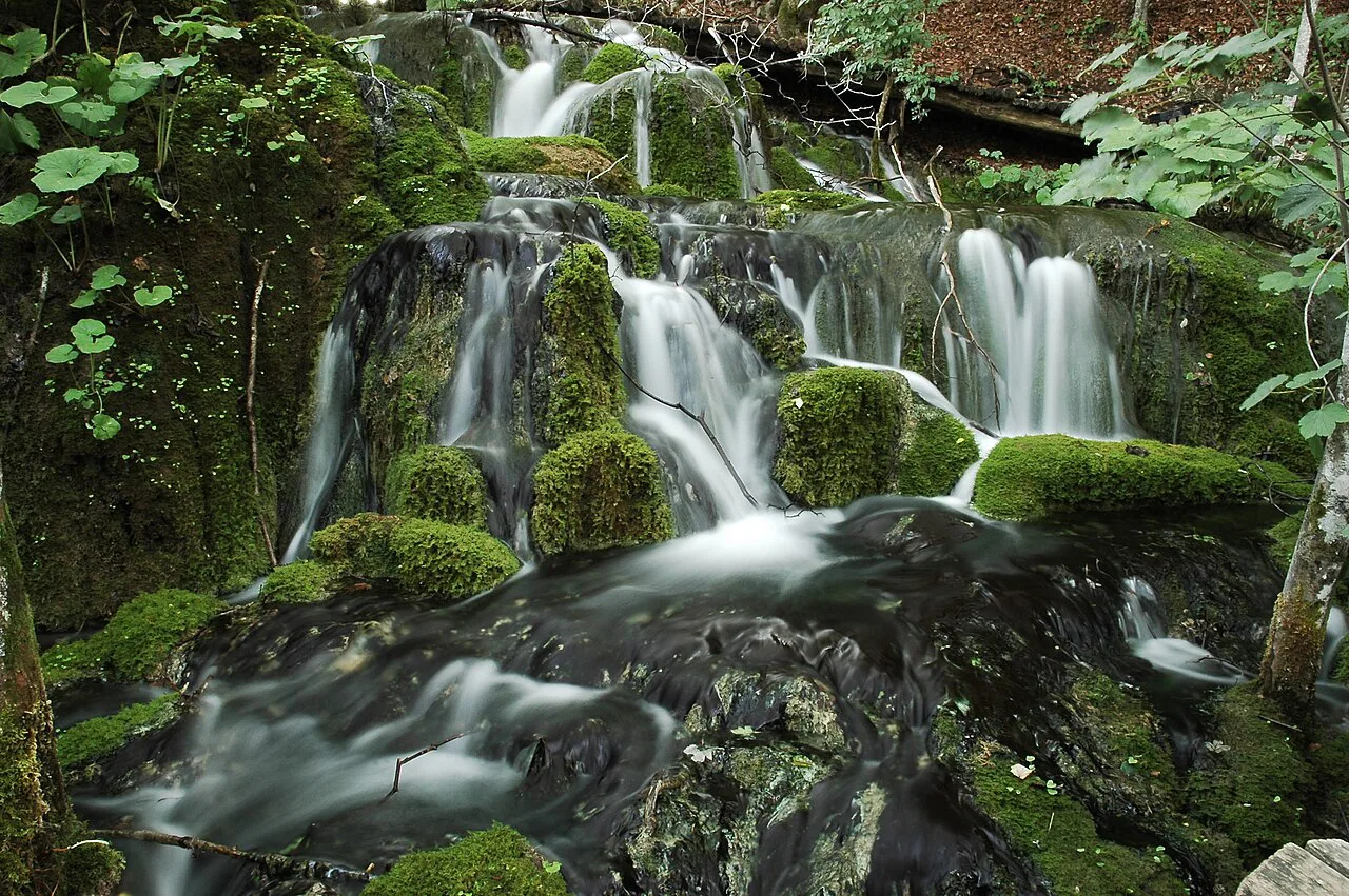 Water flowing over mossy rocks in a small waterfall at Plitvice Lakes National Park, Croatia