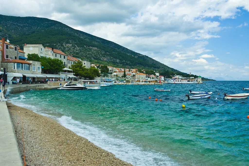 A pebble beach and turquoise water along the seafront in Bol, Brač