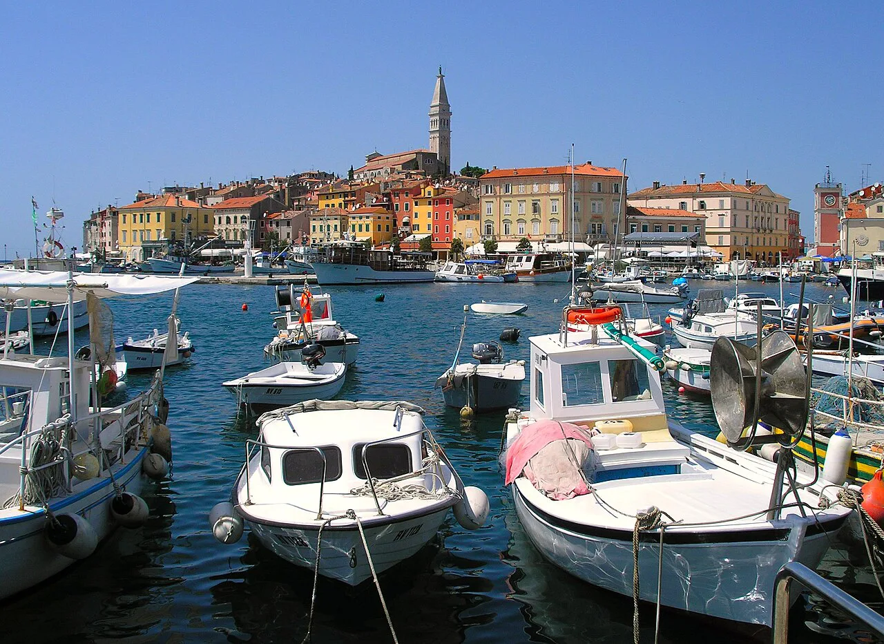 Small boats in Rovinj harbour with the old town and bell tower behind