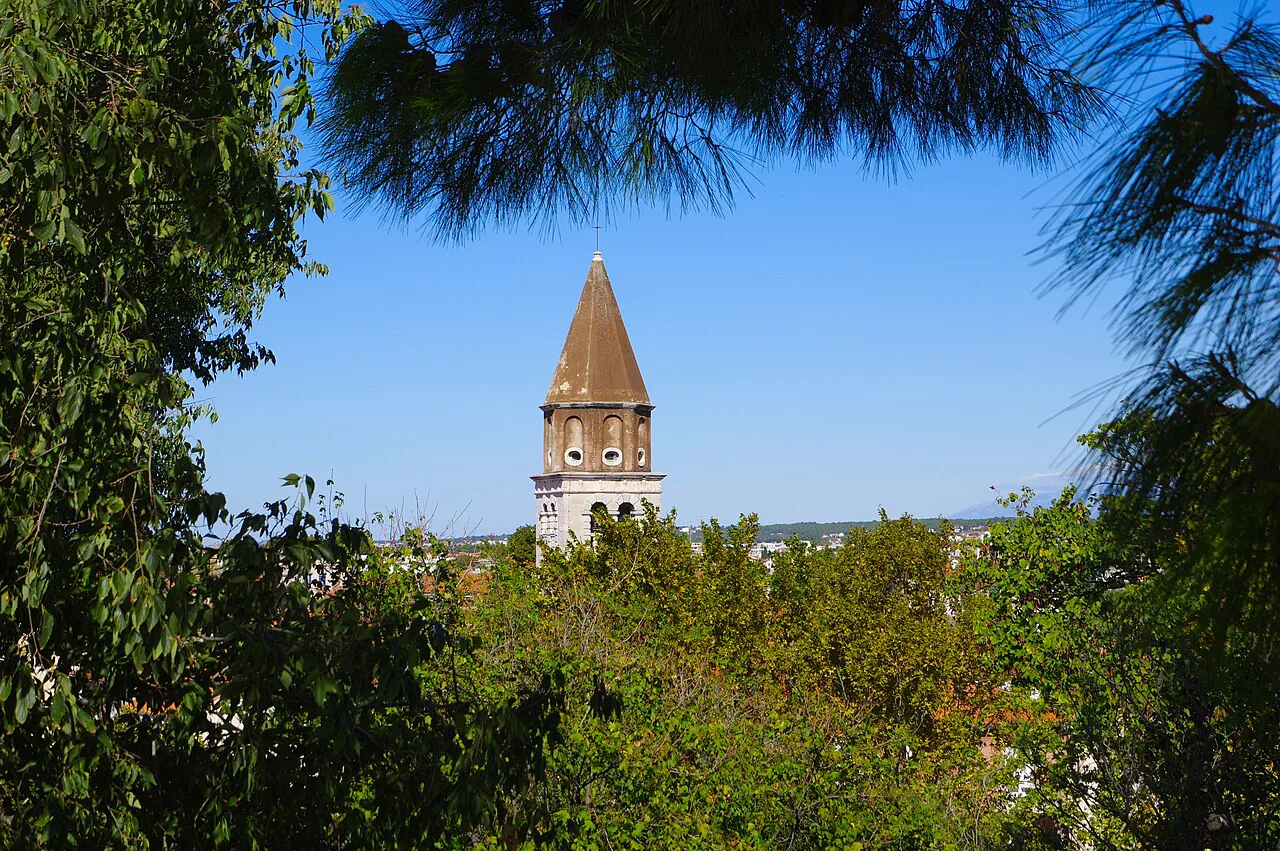 The tower of St Simeon's Church in Zadar seen through trees from the bastion