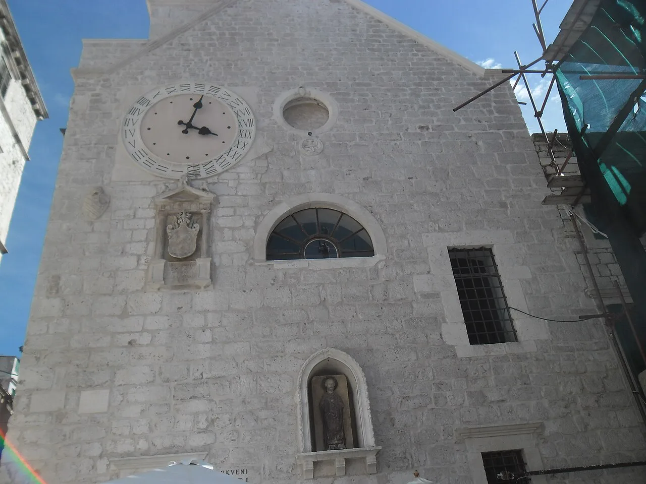 The stone façade and clock of the Church of St Barbara in Šibenik
