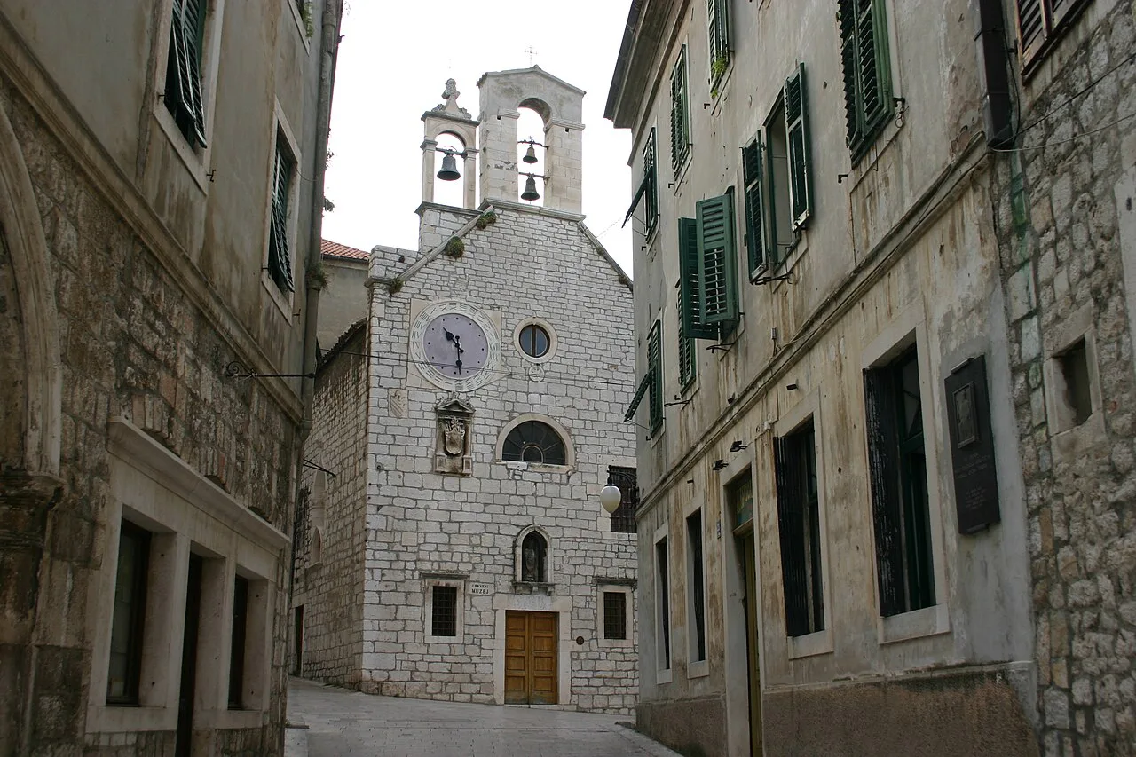 The stone facade and bell gable of the Church of St Barbara in Šibenik.