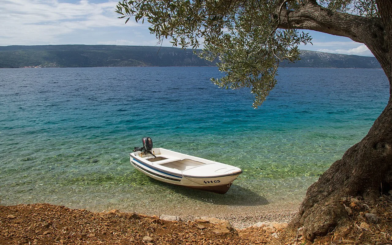 A small boat pulled up on a pebble beach on the island of Cres, Kvarner
