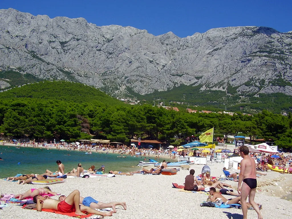Sunbathers on the pebble beach at Makarska below the Biokovo mountains, Croatia