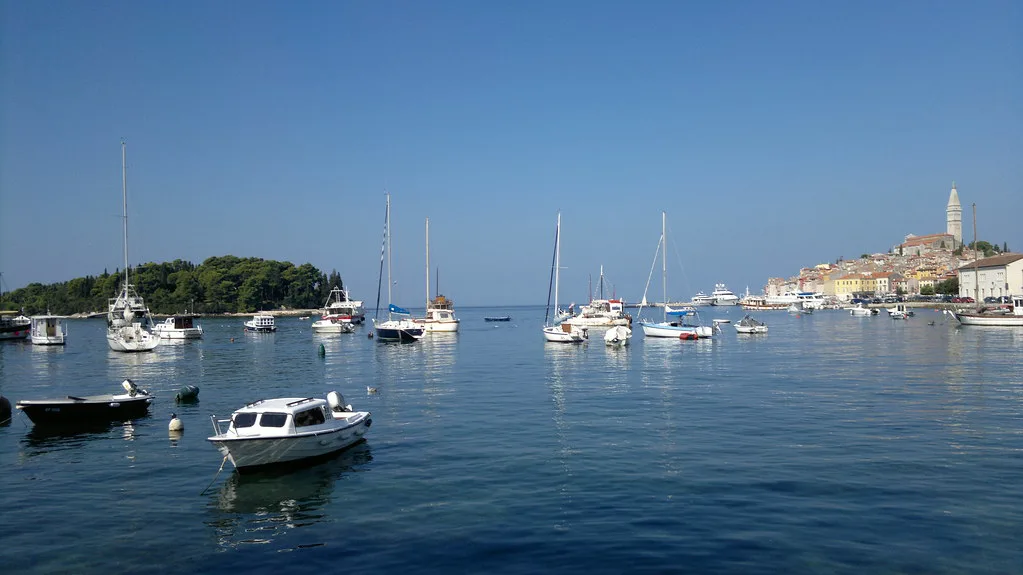 Yachts anchored in the bay with Rovinj's old town in the distance, Croatia