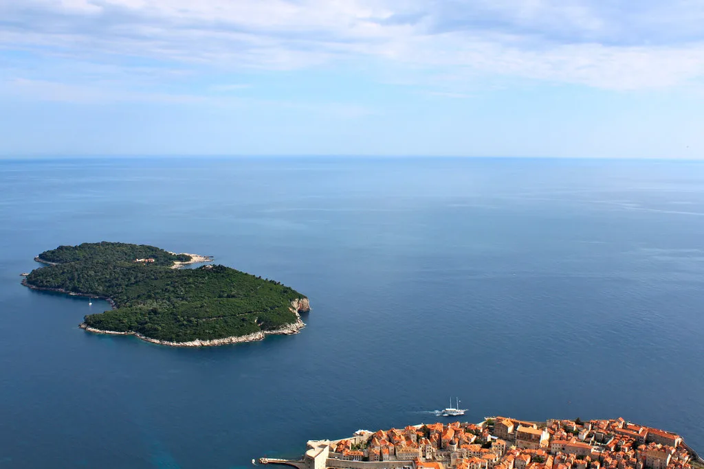 Lokrum island lying offshore beyond the rooftops of Dubrovnik's old town, Croatia