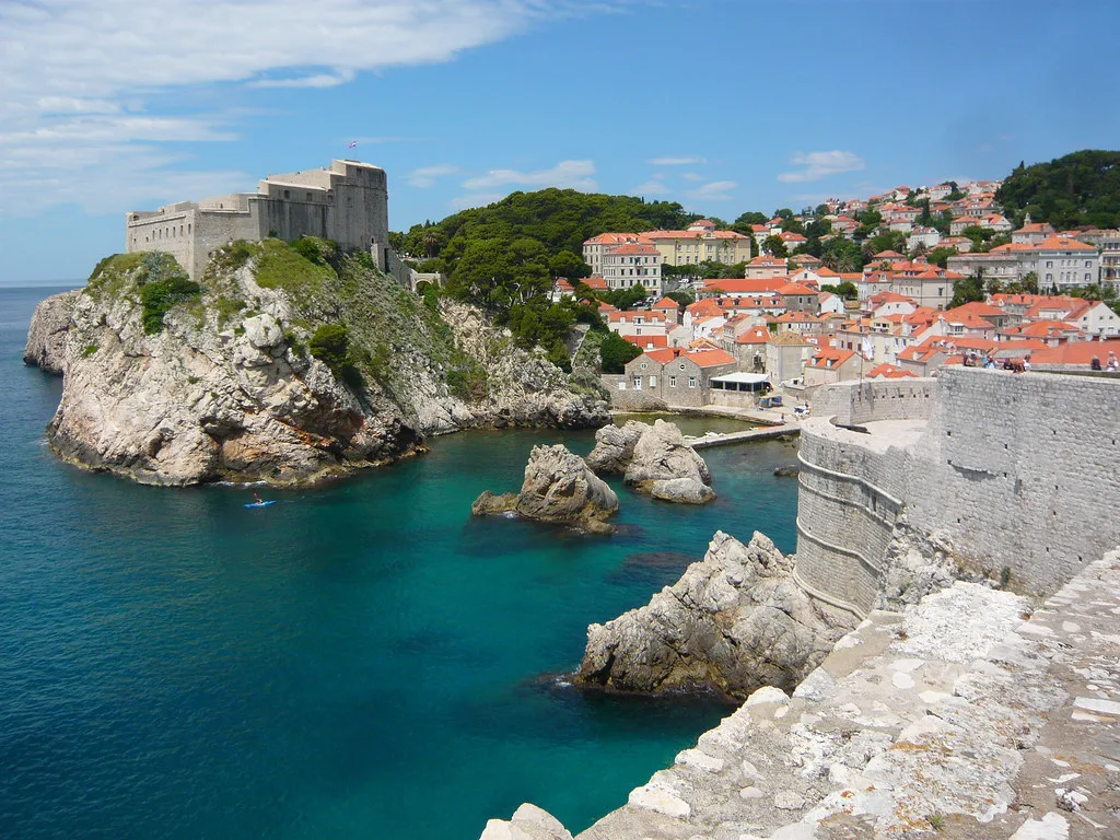 A kayaker in the sea below the cliffs and city walls of Dubrovnik, Croatia