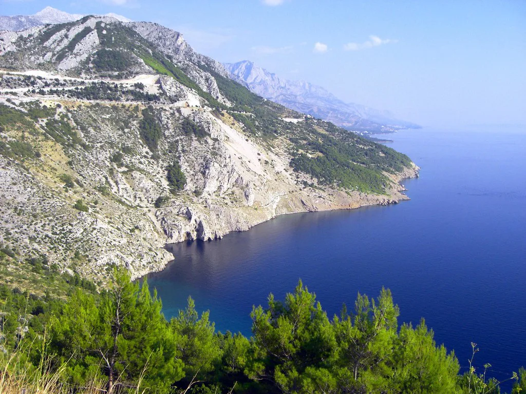 Steep mountainside dropping to deep blue sea beside the Adriatic coast road in Dalmatia, Croatia