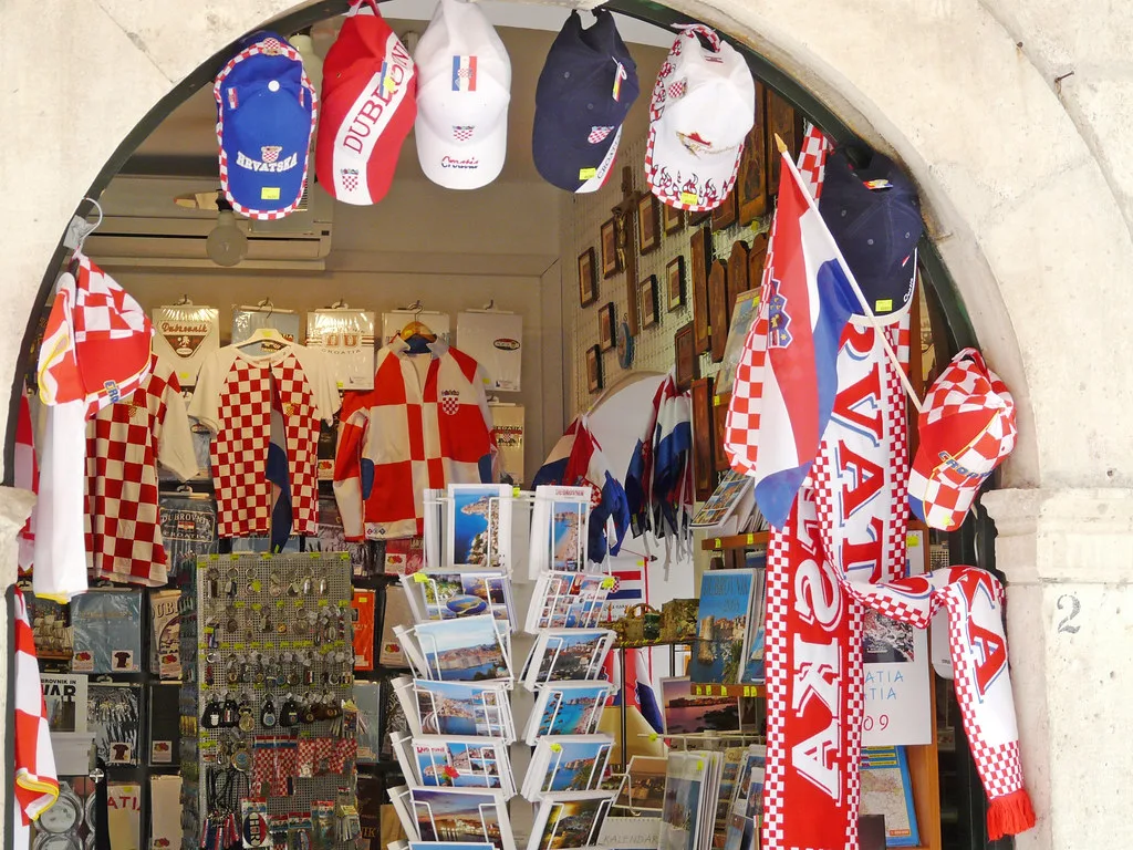 A souvenir shop doorway hung with football shirts and postcards in Dubrovnik, Croatia