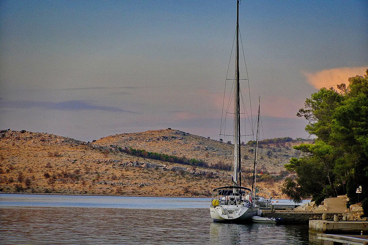 A sailing yacht moored in a quiet bay among the islands of Kornati National Park.