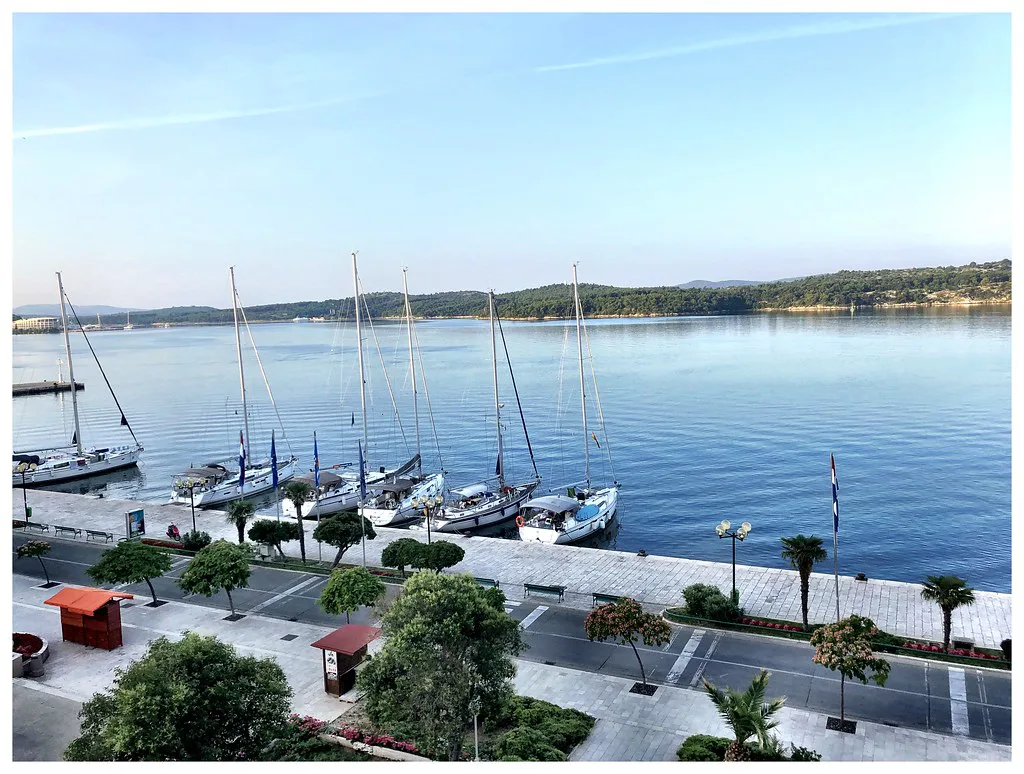 Moored yachts and palm-lined promenade along the riva in Šibenik