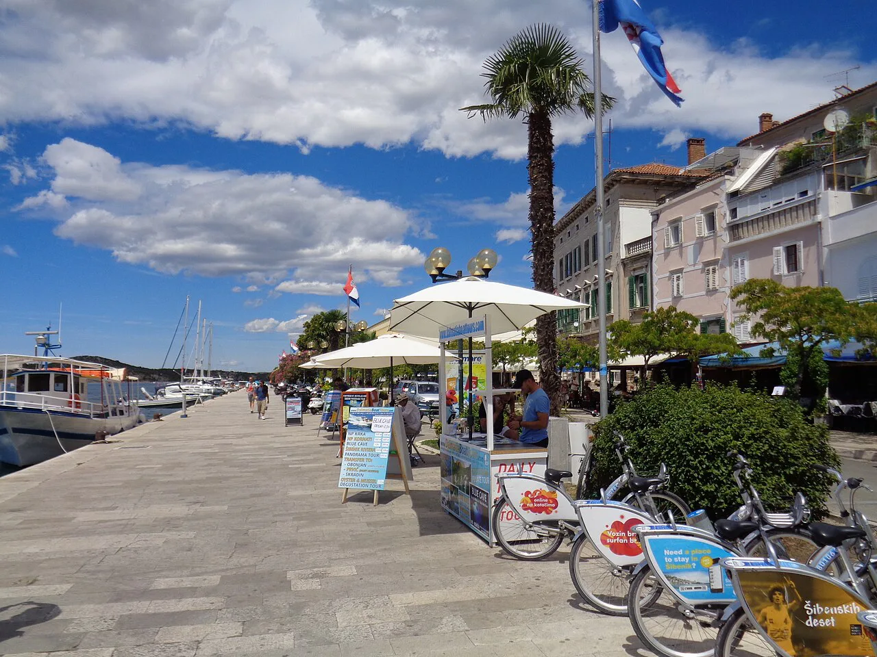 Palm trees and cafés along the Riva waterfront promenade in Šibenik.