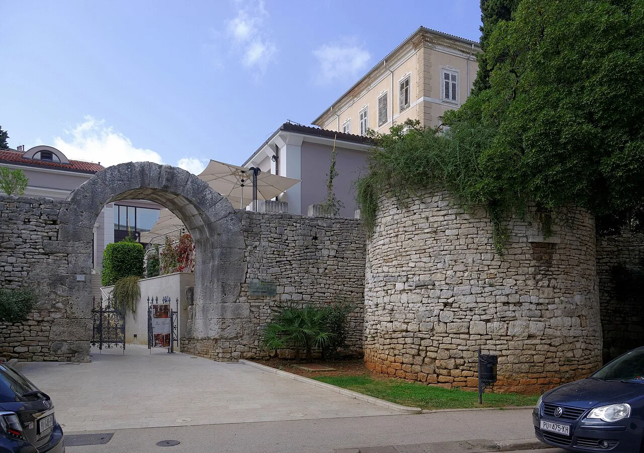 The Gate of Hercules beside a round stretch of Pula's old town wall, Pula