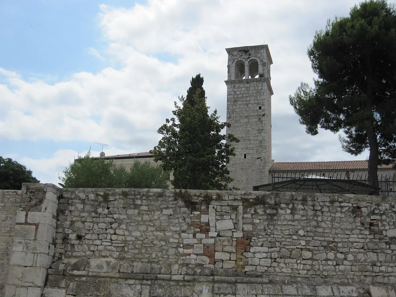 Old stone walls and a bell tower along Obala Matka Laginje in Poreč.