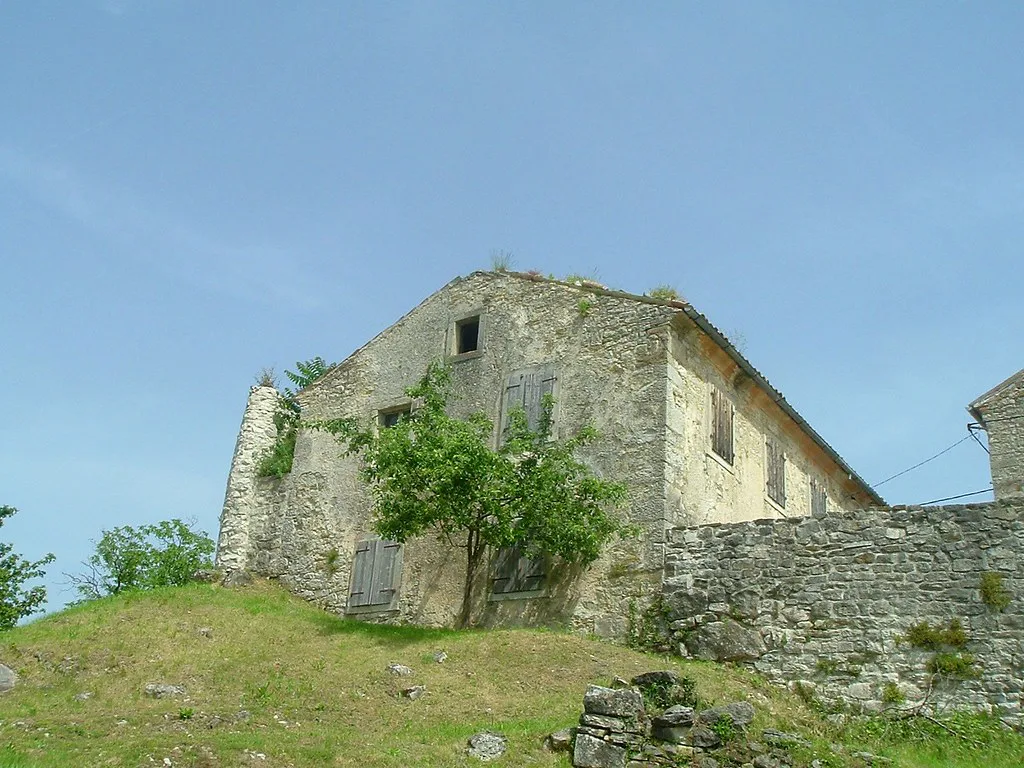 An old stone building on a grassy slope in the hill town of Hum, Istria