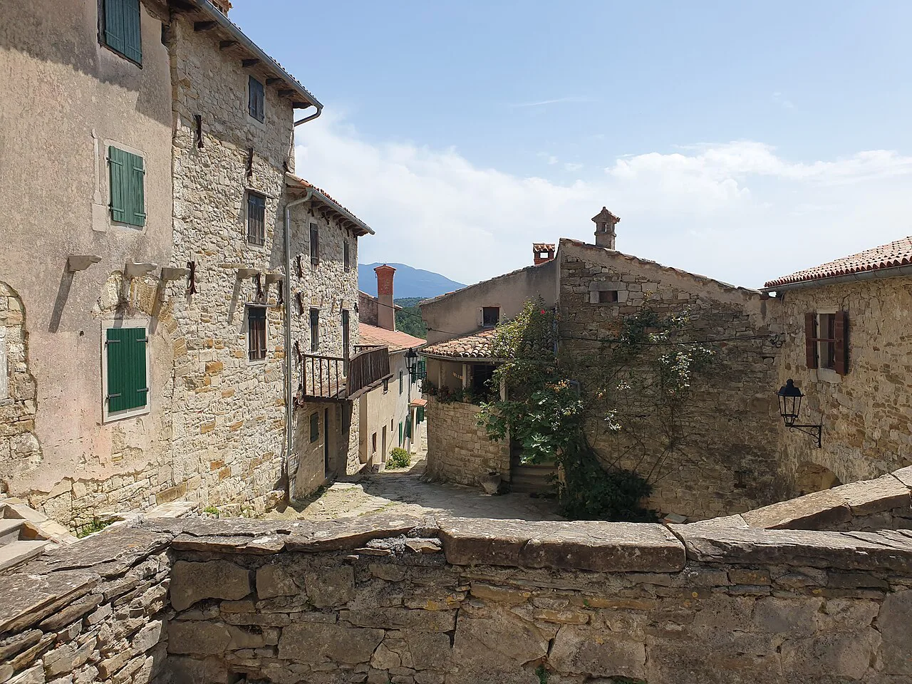 Old stone houses and a low wall in the hilltop town of Hum in Istria