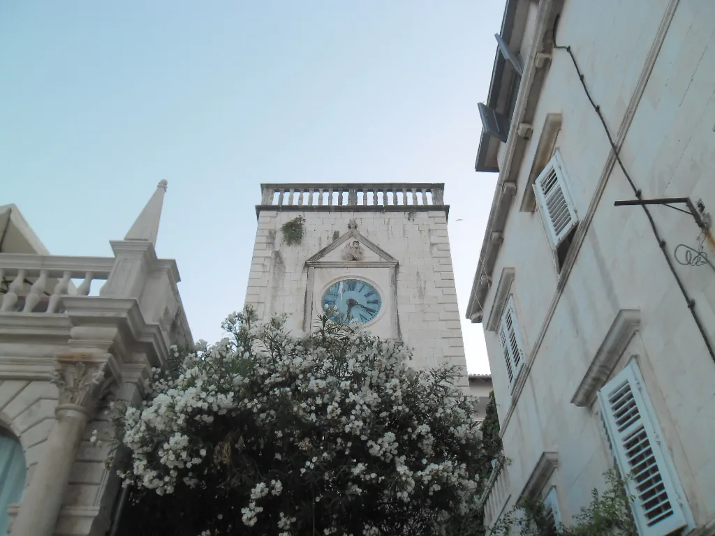 The clock tower rising above buildings in Hvar Town