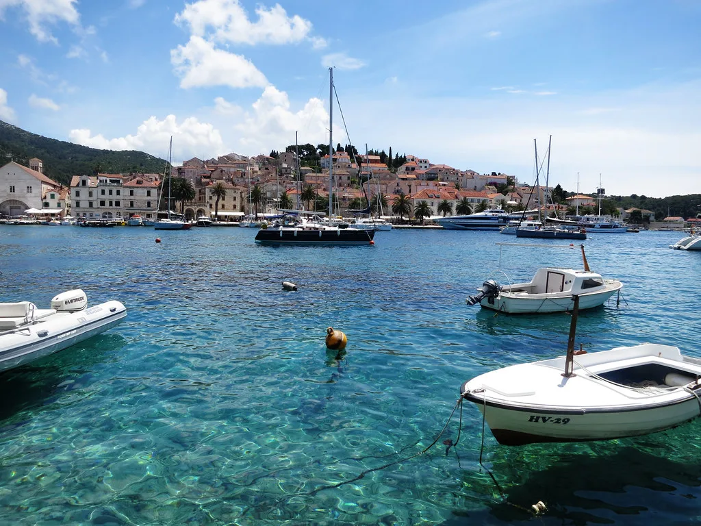 Small boats in clear water in front of the harbour of Hvar Town