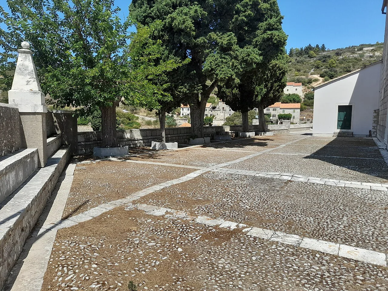 A paved square among trees in the village of Velo Grablje on Hvar