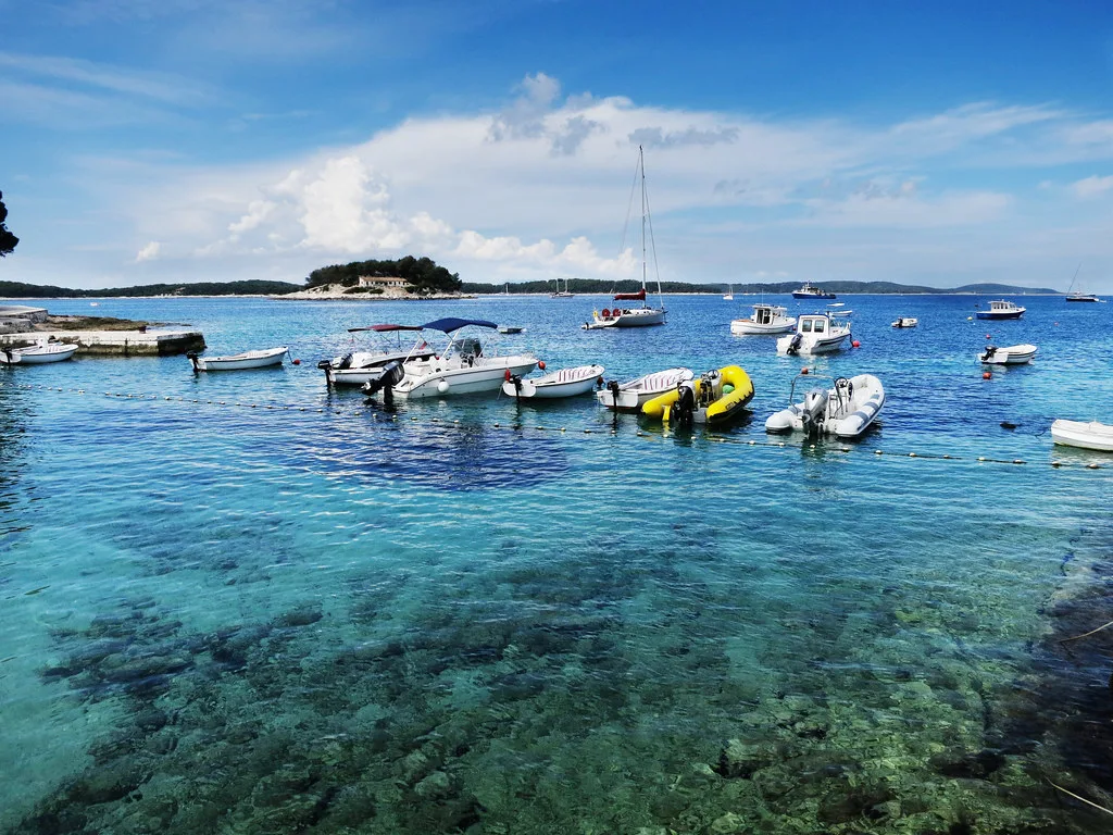 Small boats moored in a clear turquoise bay on the island of Hvar