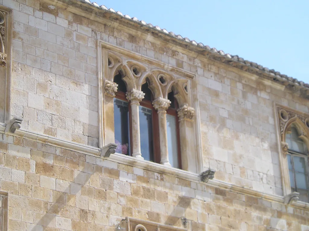 Gothic windows on the stone facade of a historic building in Hvar Town