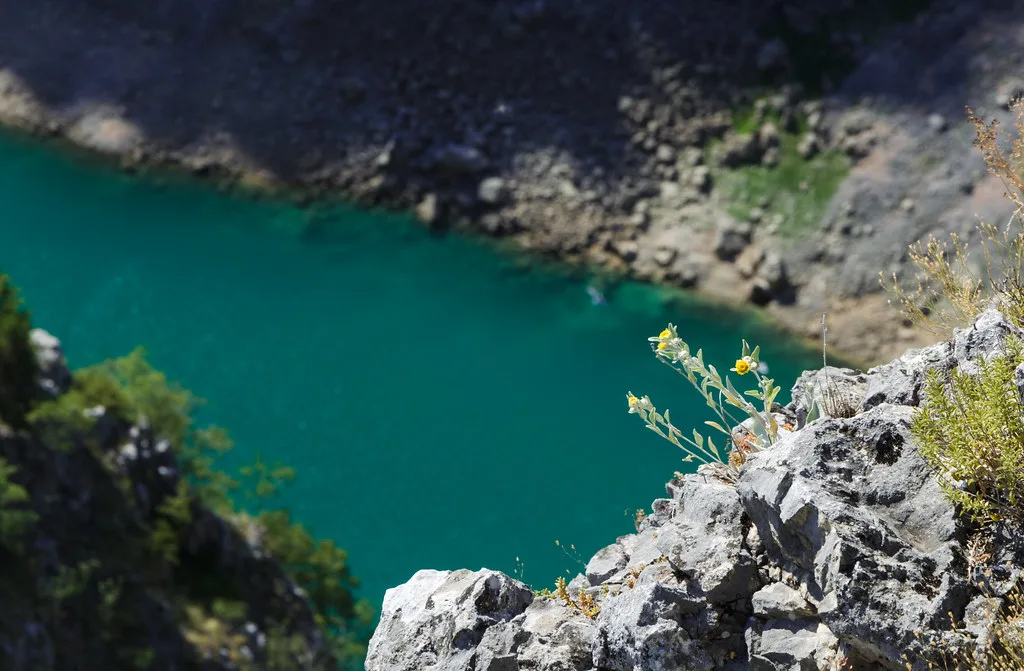 Turquoise water at the bottom of the Blue Lake sinkhole near Imotski, Dalmatia