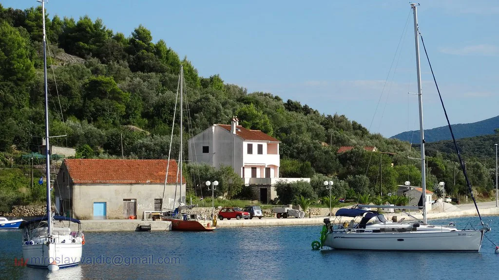 Sailing boats moored by a small harbour on the island of Mala Rava, Zadar