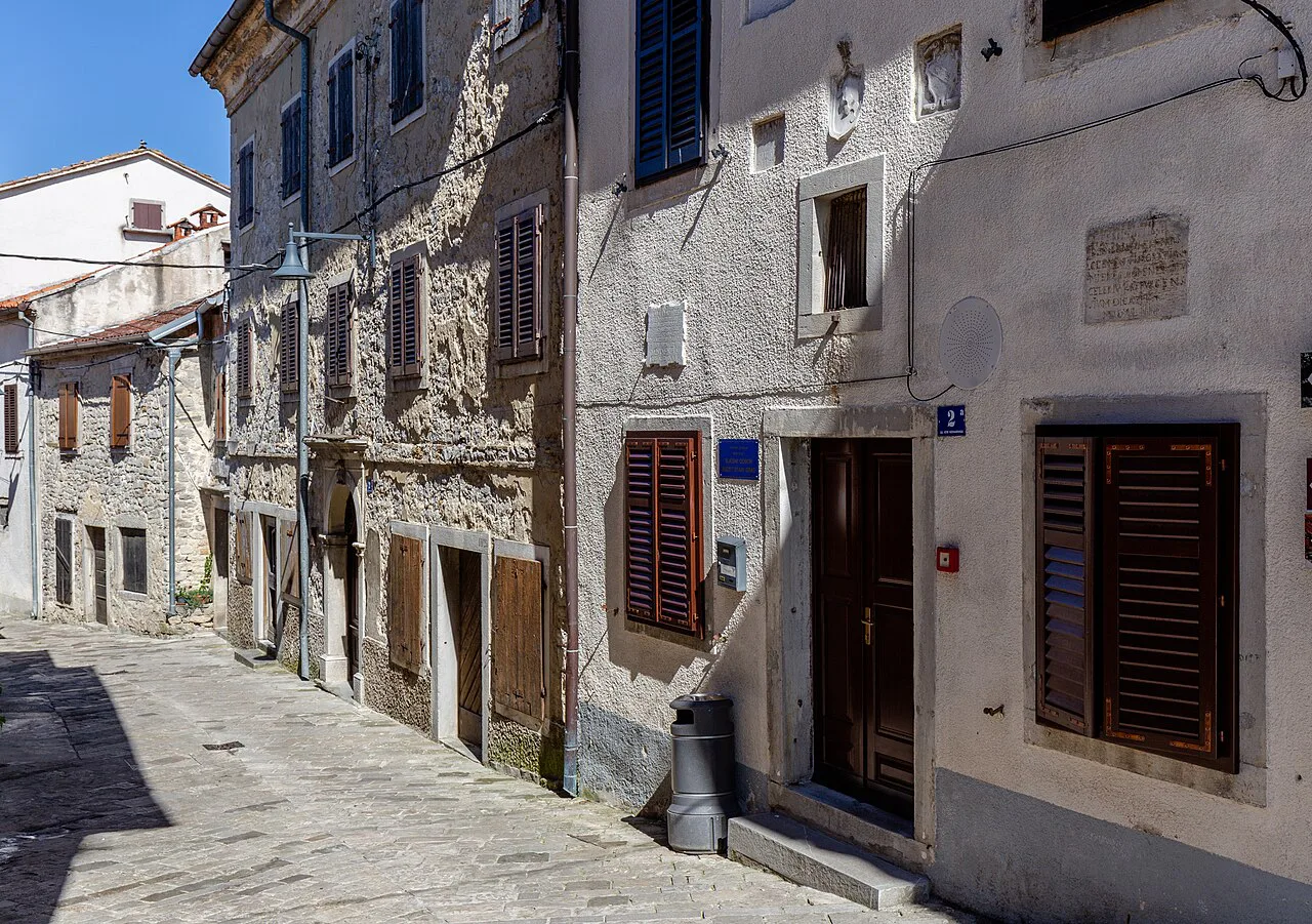 A narrow stone street lined with old houses in Buzet, Istria.