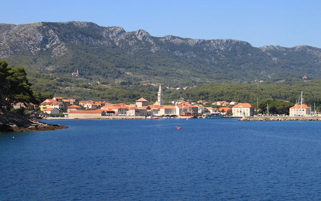 The waterfront and church tower of Jelsa below the hills of Hvar, seen across the bay