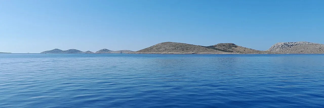 A chain of low, bare islands on the horizon in Kornati National Park, Croatia