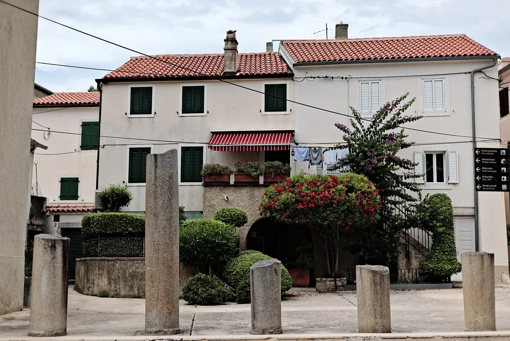 Old houses and stone columns on a street in the old town of Krk, Kvarner