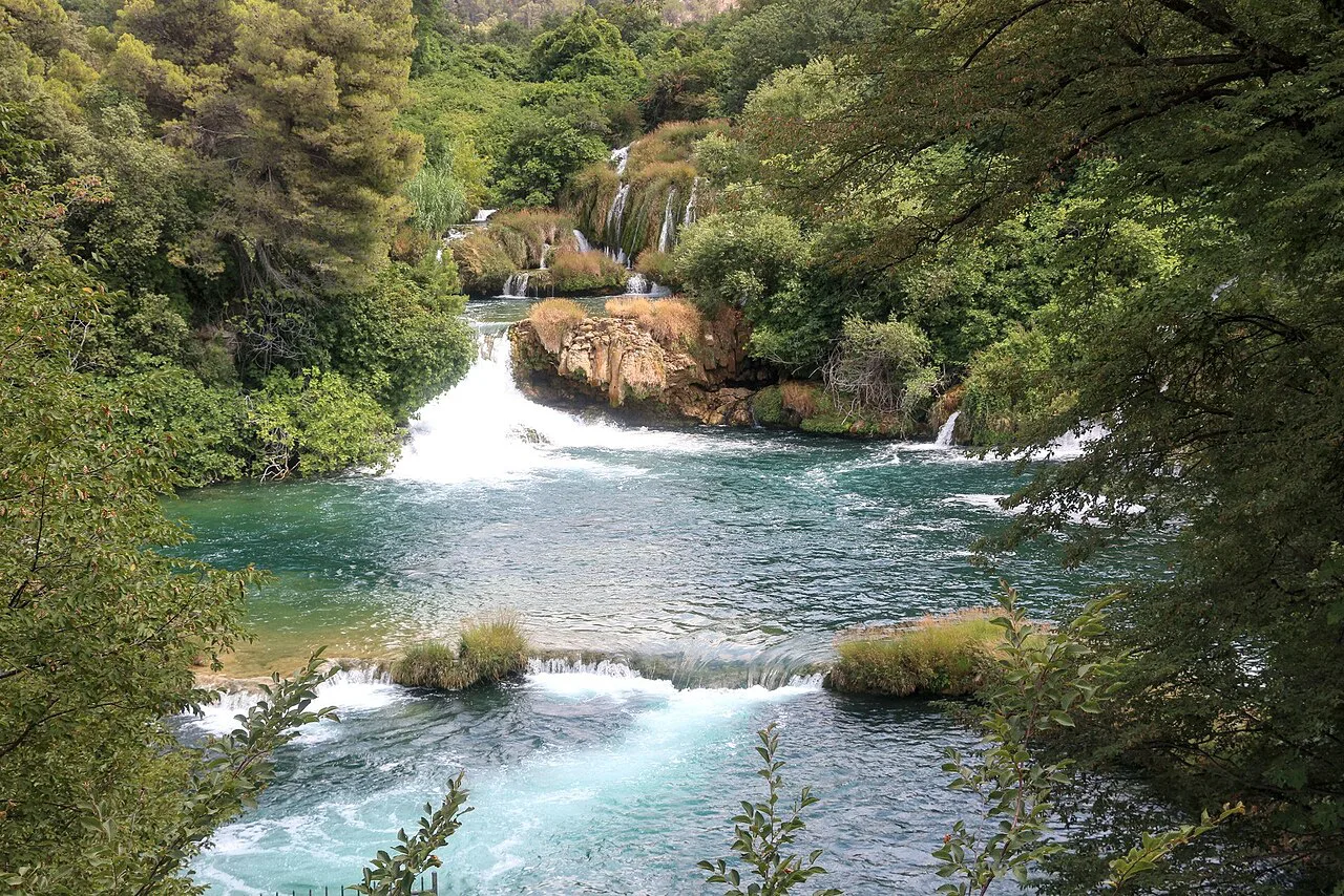 White water tumbling over rocks between trees in Krka National Park