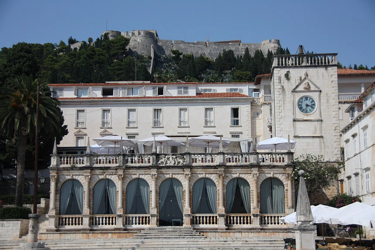 The loggia on the main square of Hvar Town with the fortress on the hill behind