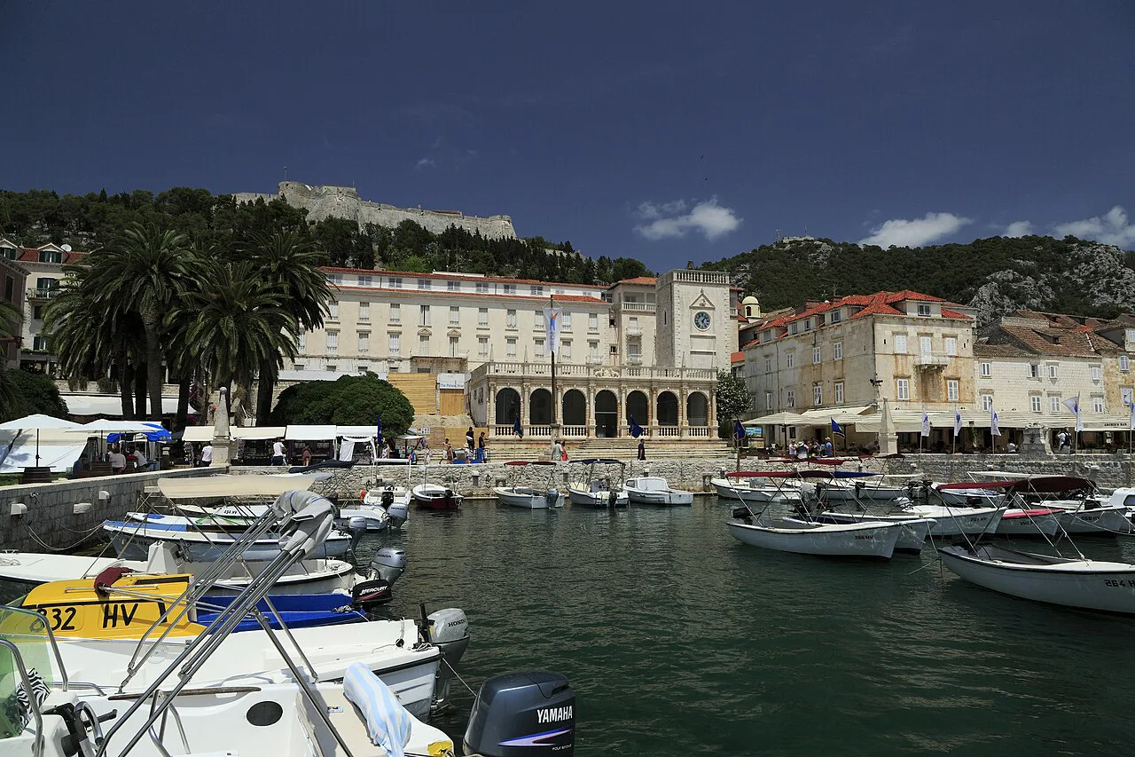 Boats in Hvar harbour with the loggia and the Španjola fortress above