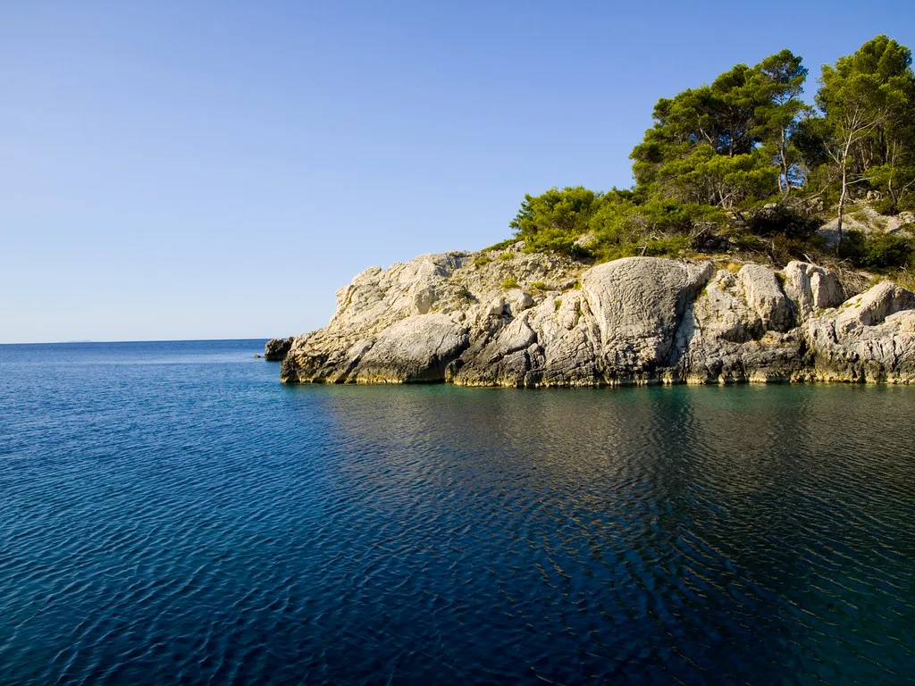 A pine-topped rocky islet in clear blue water near Lumbarda on Korčula.