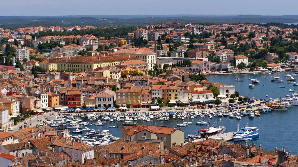 Rooftops and the boat-filled harbour of Rovinj seen from above.
