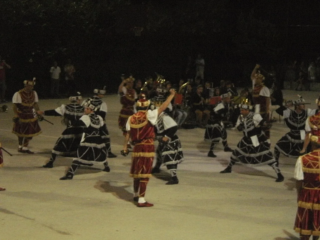 Moreška sword dancers clashing swords during an evening performance.