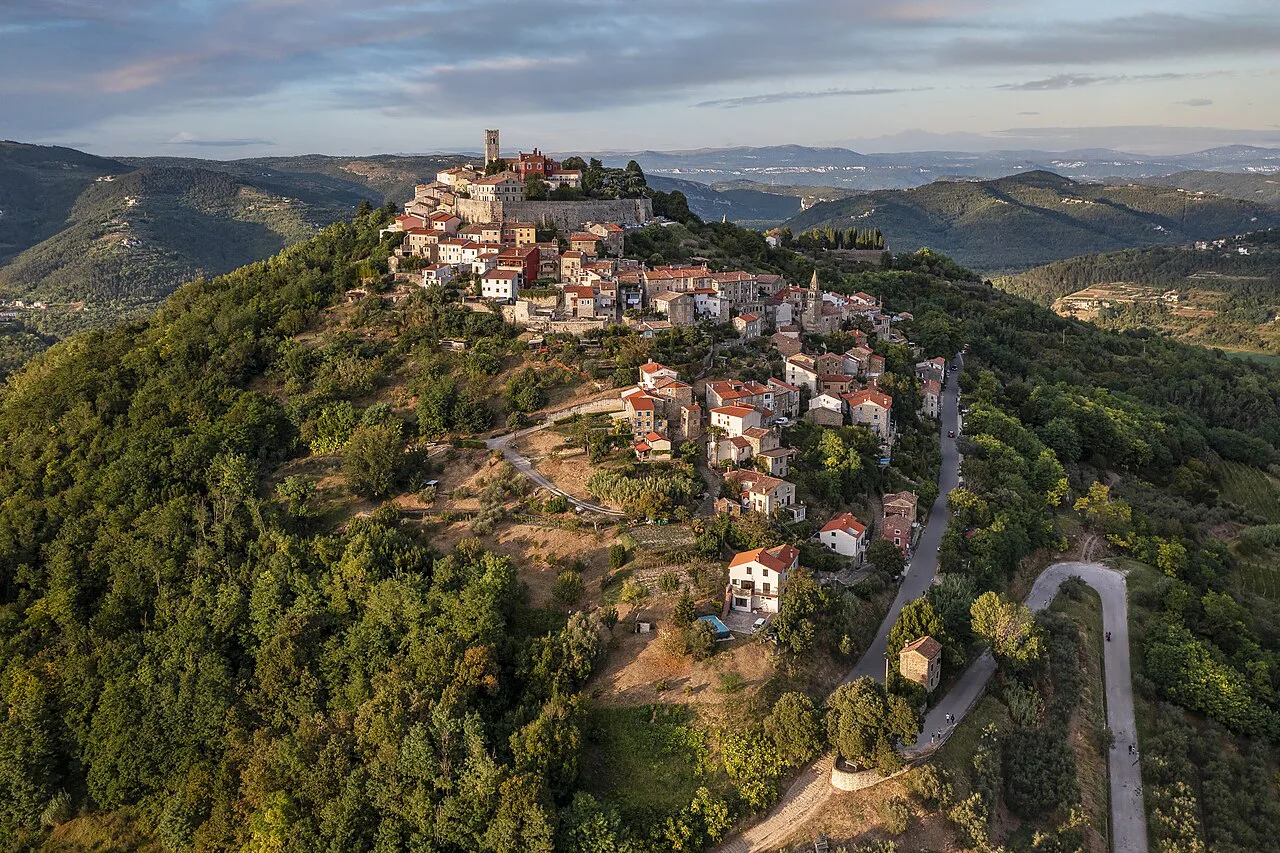 Aerial view of the hilltop town of Motovun surrounded by green woodland, Istria