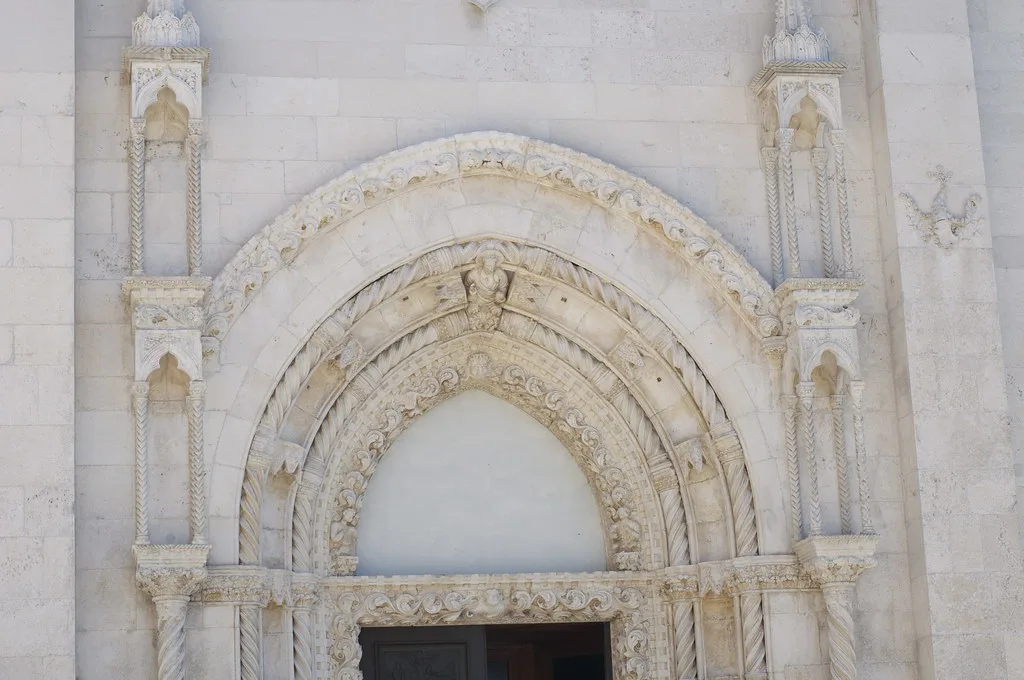 A carved Gothic stone doorway on a historic building in Šibenik