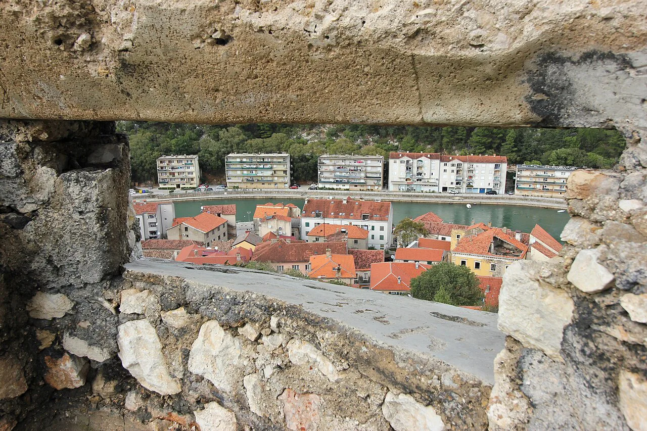 Rooftops of Obrovac and the river seen through an opening in the fortress wall.
