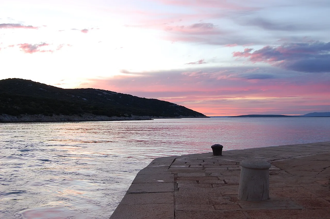 Sunset over the sea seen from a stone quay at Osor, Kvarner