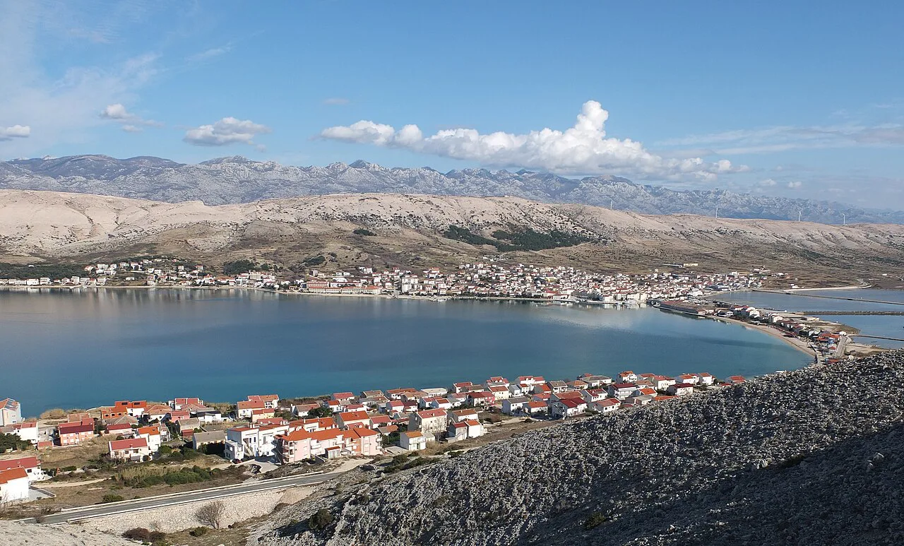The town of Pag beside its bay, with bare hills behind, Zadar