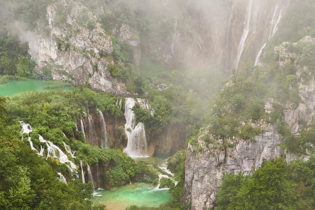 Waterfalls tumbling over mossy cliffs into turquoise pools at Plitvice Lakes