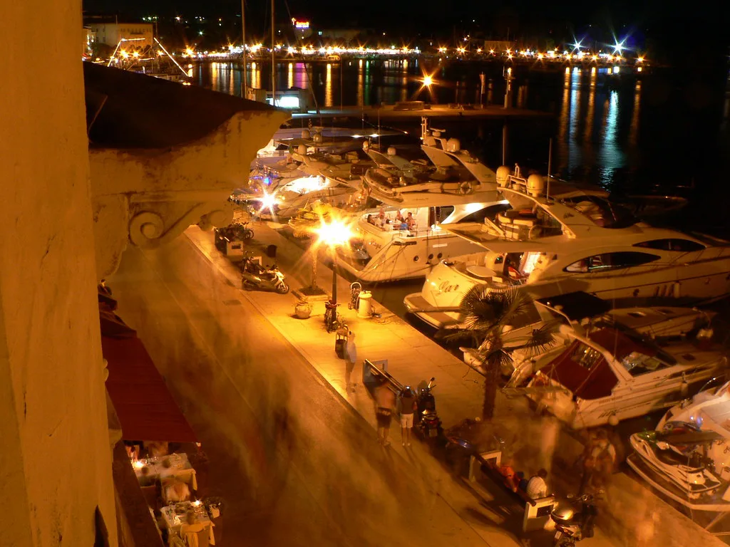Motorboats moored along the lit Poreč waterfront in the evening