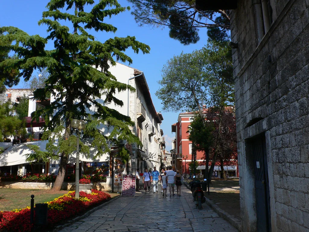A tree-lined stone street in the old town of Poreč in Istria