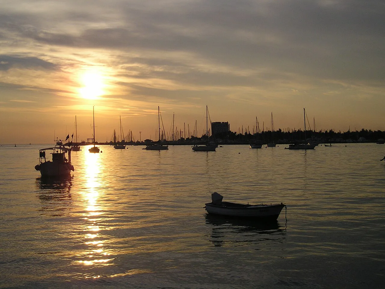 Boats on the calm water off Poreč at sunset