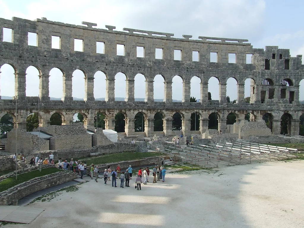 Visitors inside the Roman amphitheatre in Pula beneath its arched outer wall